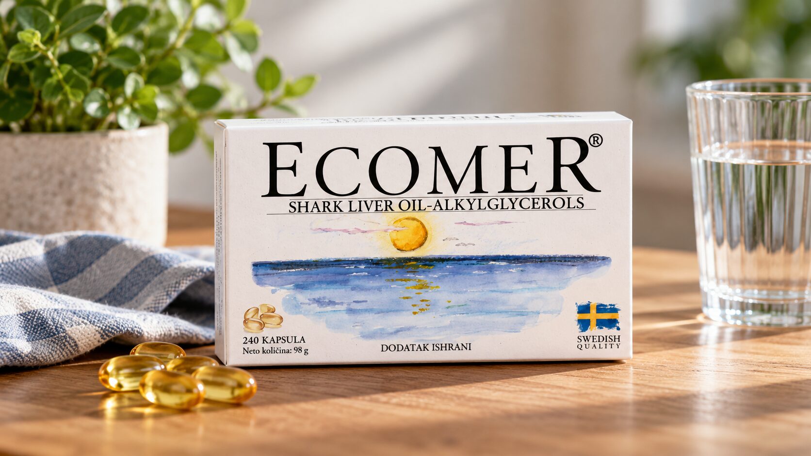 Kutija Ecomer suplementa sa kapsulama ulja ajkuline jetre na drvenom stolu.